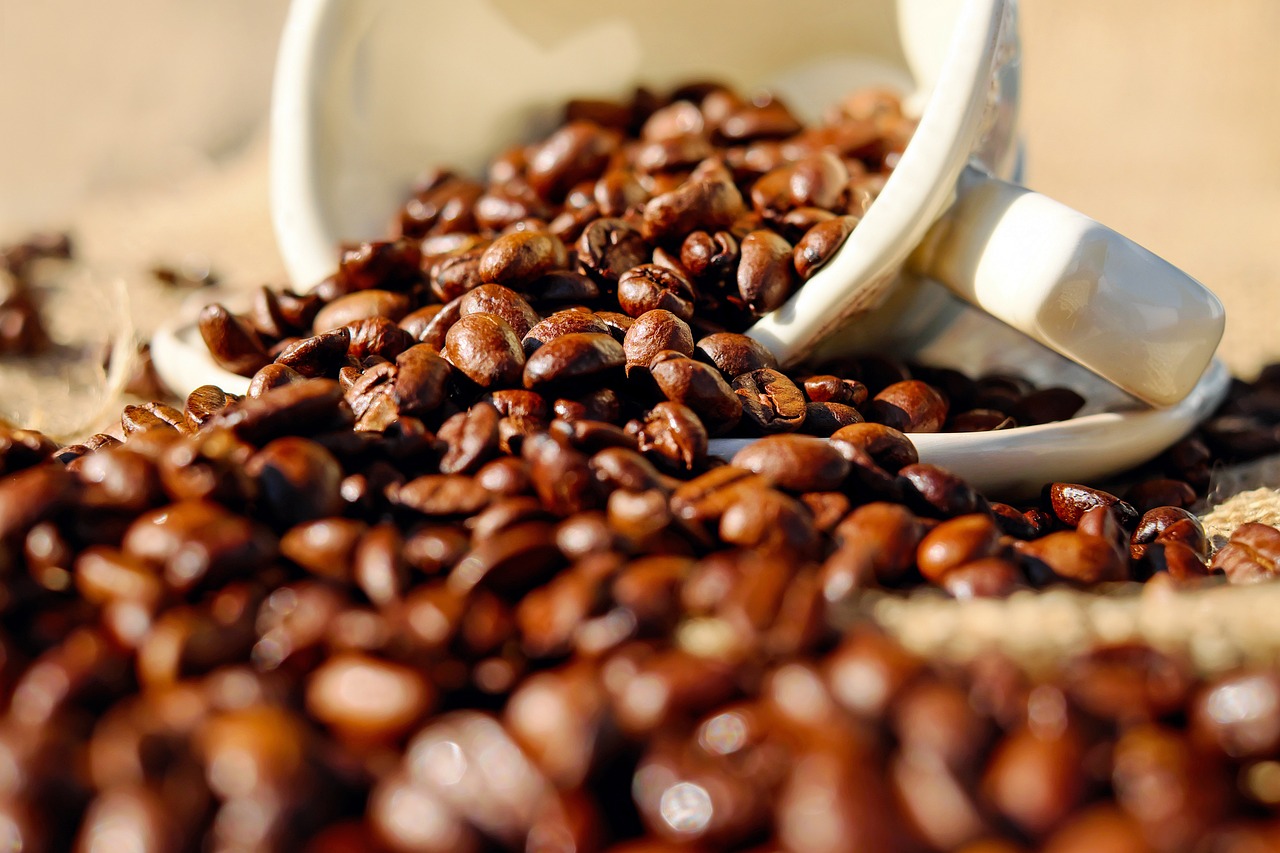 Xícara derrubada em uma mesa com grãos de café